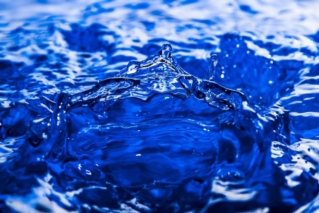 Captivating close-up of a vibrant blue water splash, perfect for backgrounds.